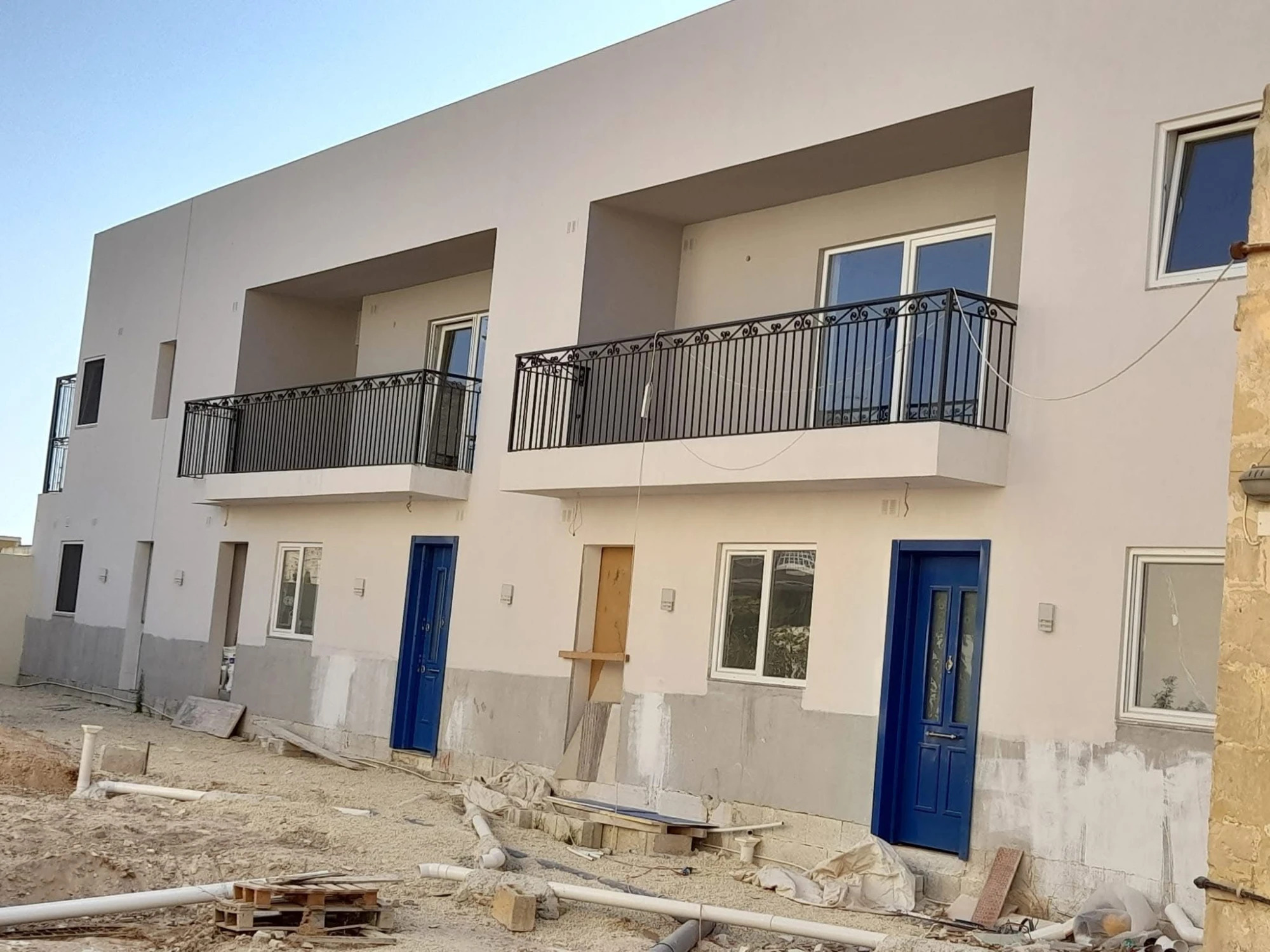 Modern townhouses with blue doors and iron railings