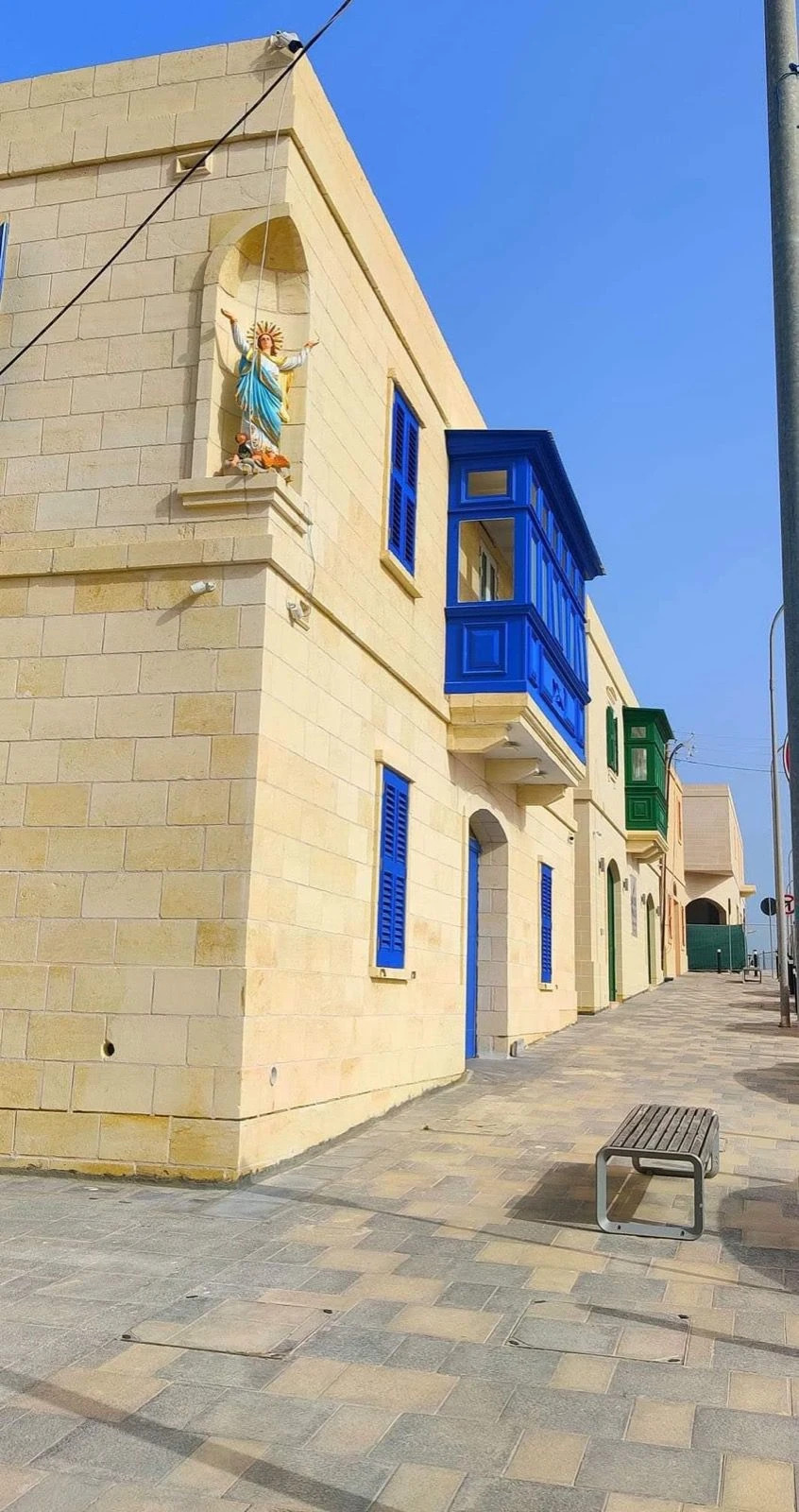 Completed limestone row houses with blue gallarija, Malta